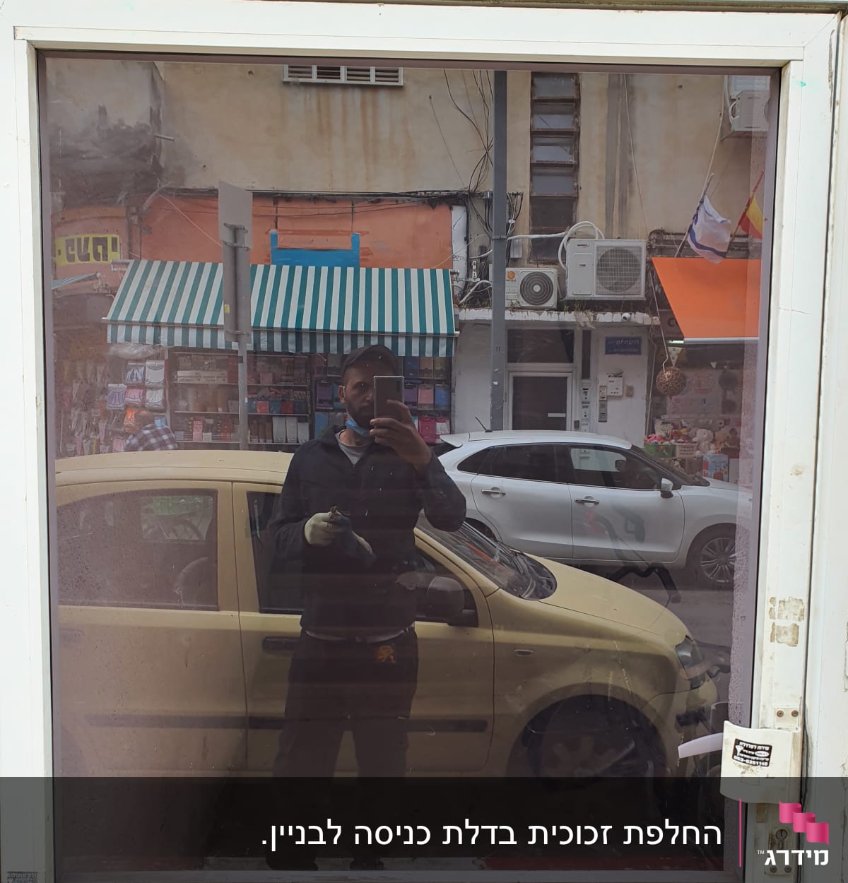 חלון זכוכית עם השתקפות של אדם ומכונית